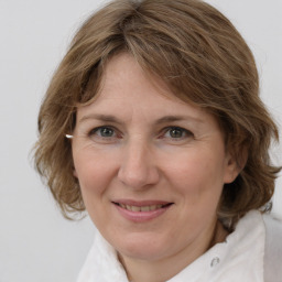 Joyful white adult female with medium  brown hair and grey eyes