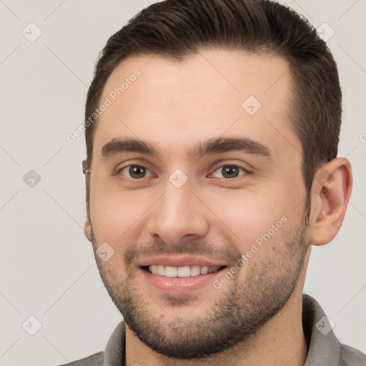 Joyful white young-adult male with short  brown hair and brown eyes