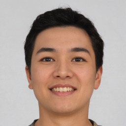 Joyful asian young-adult male with short  brown hair and brown eyes