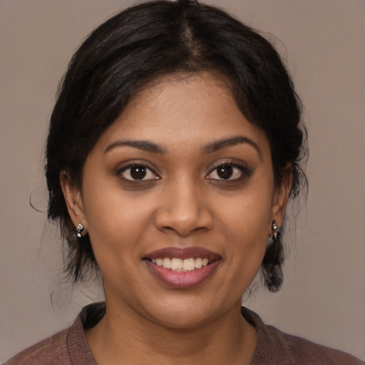 Joyful black young-adult female with medium  brown hair and brown eyes