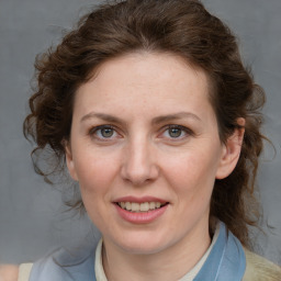 Joyful white adult female with medium  brown hair and blue eyes