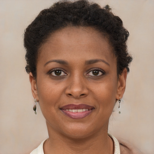 Joyful black young-adult female with short  brown hair and brown eyes