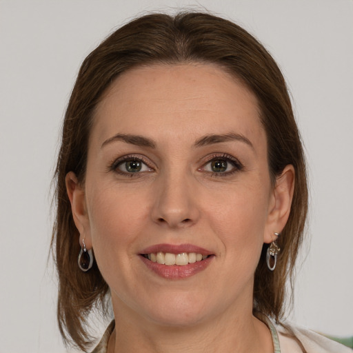 Joyful white young-adult female with medium  brown hair and grey eyes