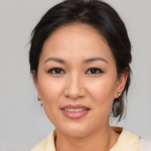 Joyful asian adult female with medium  brown hair and brown eyes