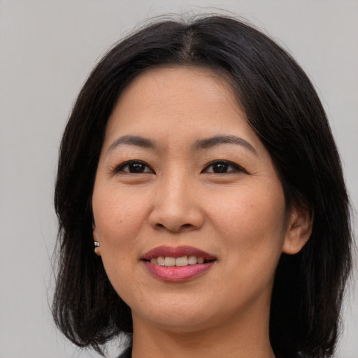 Joyful asian young-adult female with medium  brown hair and brown eyes