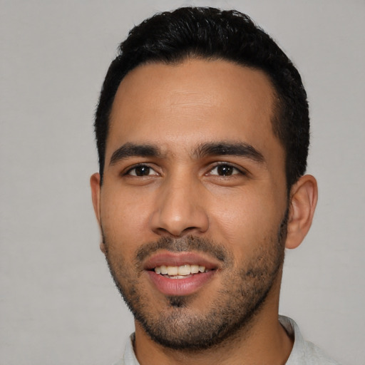 Joyful latino young-adult male with short  black hair and brown eyes