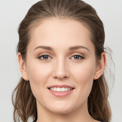 Joyful white young-adult female with long  brown hair and grey eyes