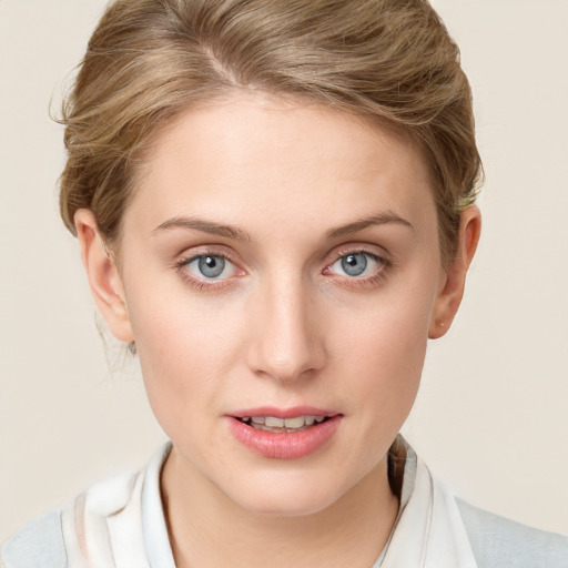 Joyful white young-adult female with short  brown hair and blue eyes