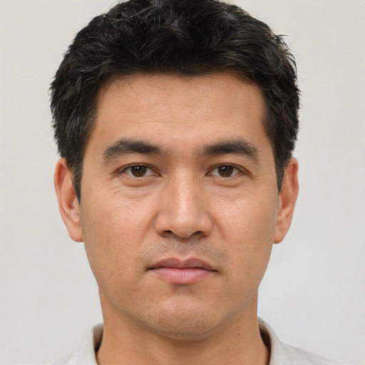 Joyful asian adult male with short  brown hair and brown eyes