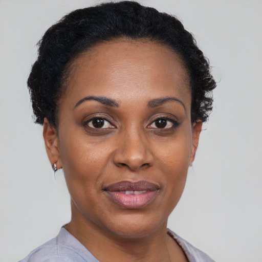 Joyful black adult female with short  brown hair and brown eyes