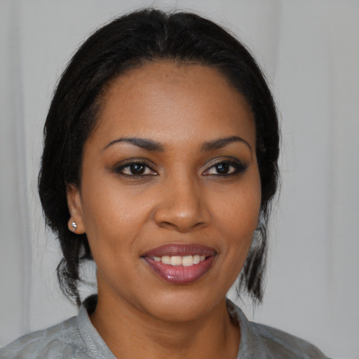 Joyful black young-adult female with medium  brown hair and brown eyes