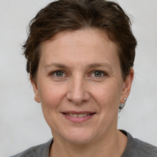 Joyful white adult female with short  brown hair and grey eyes