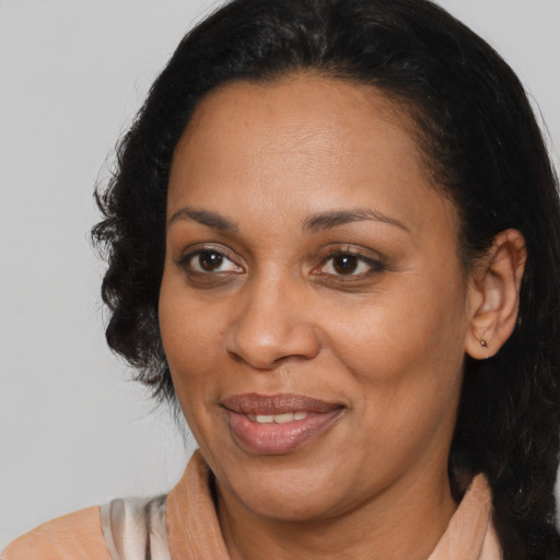 Joyful black adult female with medium  brown hair and brown eyes
