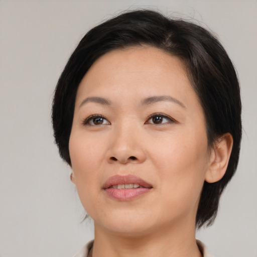 Joyful asian adult female with medium  black hair and brown eyes