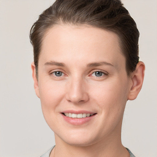 Joyful white young-adult female with short  brown hair and grey eyes