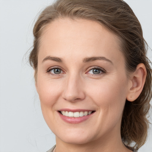 Joyful white young-adult female with medium  brown hair and grey eyes