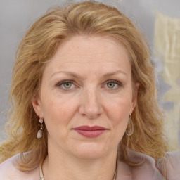 Joyful white adult female with medium  brown hair and blue eyes