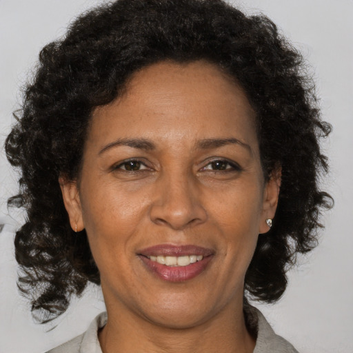 Joyful black adult female with medium  brown hair and brown eyes