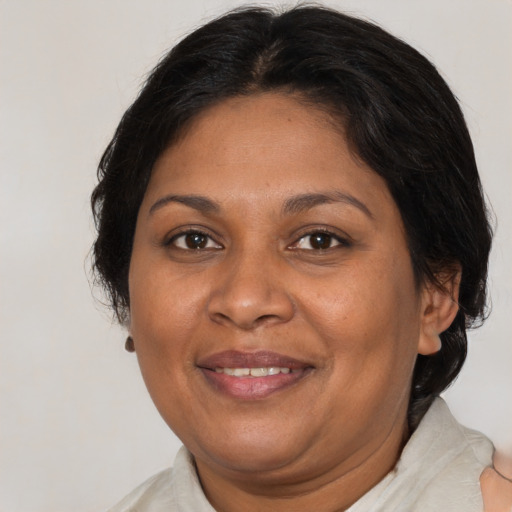 Joyful black adult female with medium  brown hair and brown eyes