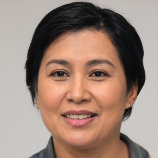 Joyful asian adult female with medium  brown hair and brown eyes