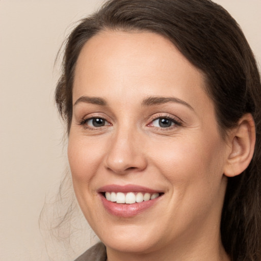 Joyful white young-adult female with long  brown hair and brown eyes