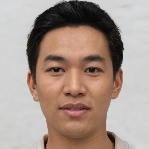 Joyful asian young-adult male with short  black hair and brown eyes
