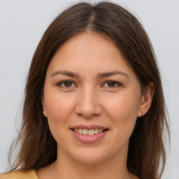 Joyful white young-adult female with long  brown hair and brown eyes