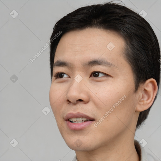 Joyful asian young-adult male with short  brown hair and brown eyes