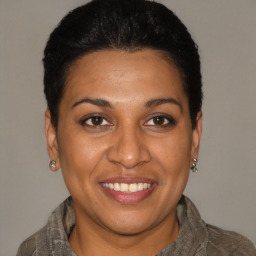 Joyful latino young-adult female with short  black hair and brown eyes