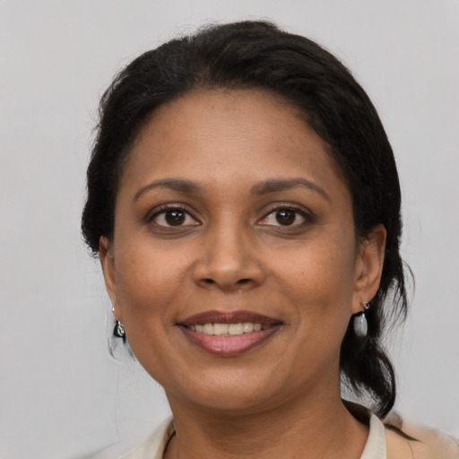 Joyful black adult female with medium  brown hair and brown eyes