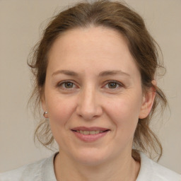 Joyful white adult female with medium  brown hair and brown eyes