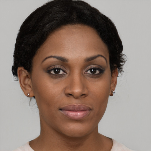 Joyful black young-adult female with short  black hair and brown eyes