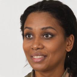 Joyful black young-adult female with long  brown hair and brown eyes