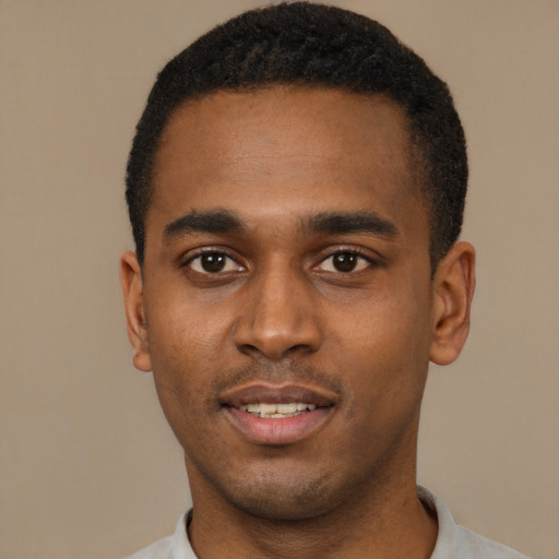 Joyful black young-adult male with short  black hair and brown eyes