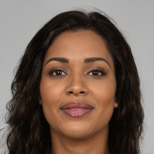 Joyful black young-adult female with long  brown hair and brown eyes