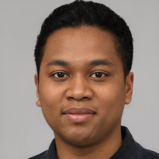 Joyful black young-adult male with short  black hair and brown eyes