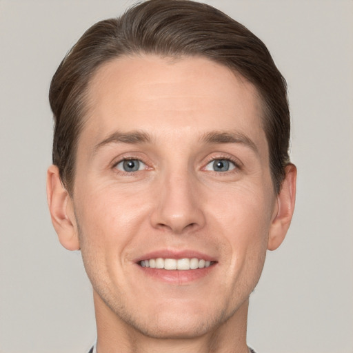 Joyful white adult male with short  brown hair and grey eyes