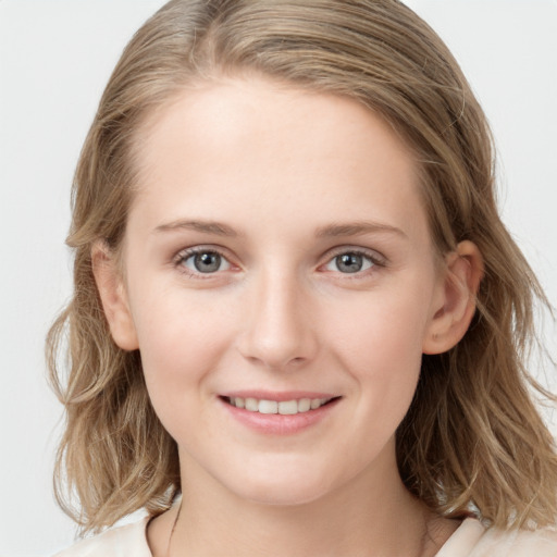 Joyful white young-adult female with medium  brown hair and blue eyes