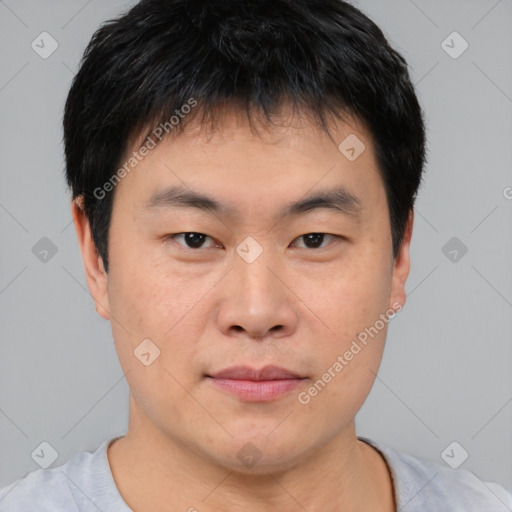 Joyful asian young-adult male with short  brown hair and brown eyes