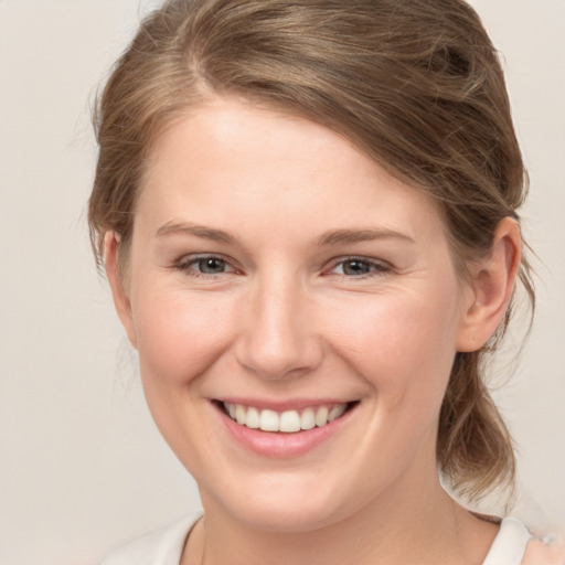 Joyful white young-adult female with medium  brown hair and grey eyes