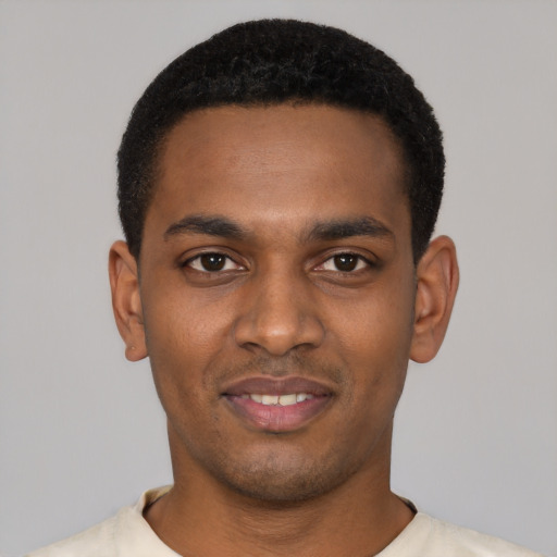 Joyful black young-adult male with short  black hair and brown eyes