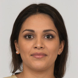 Joyful latino young-adult female with medium  brown hair and brown eyes