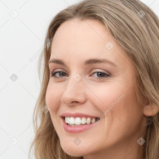 Joyful white young-adult female with long  brown hair and blue eyes