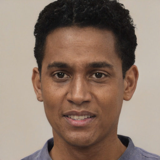 Joyful black young-adult male with short  black hair and brown eyes
