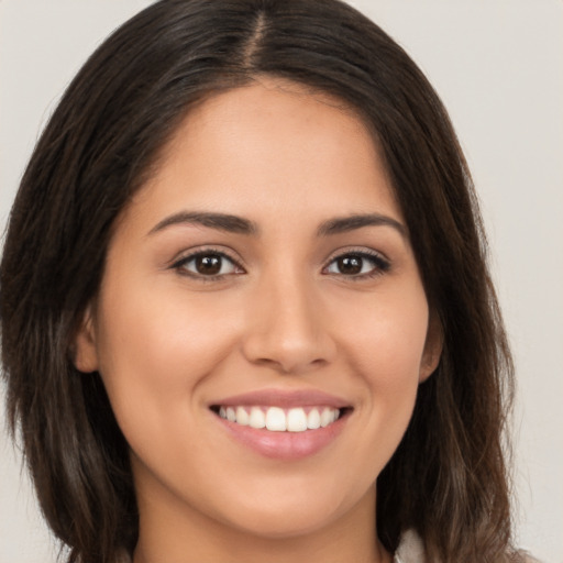 Joyful white young-adult female with long  brown hair and brown eyes