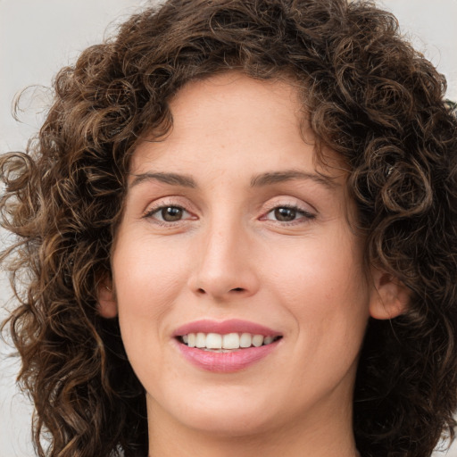 Joyful white young-adult female with medium  brown hair and green eyes