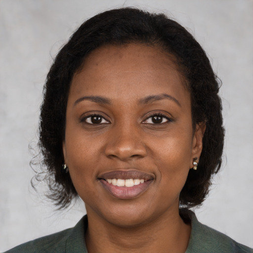 Joyful black young-adult female with medium  brown hair and brown eyes
