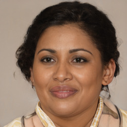 Joyful latino adult female with medium  brown hair and brown eyes