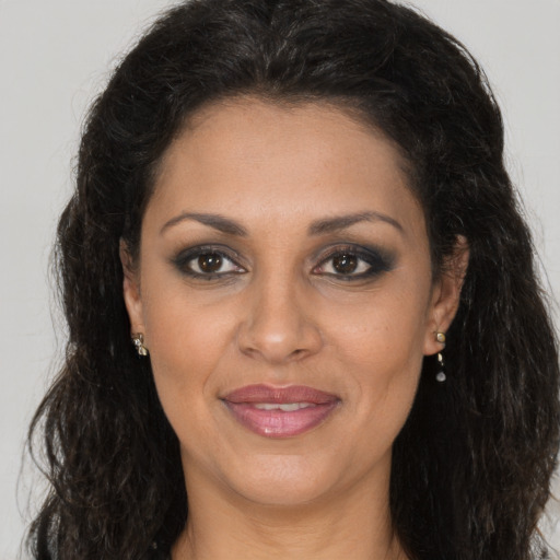 Joyful black adult female with long  brown hair and brown eyes