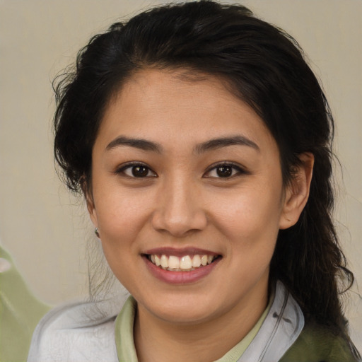 Joyful latino young-adult female with medium  brown hair and brown eyes